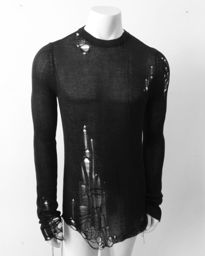 Mannequin wearing a black shredded knit sweater