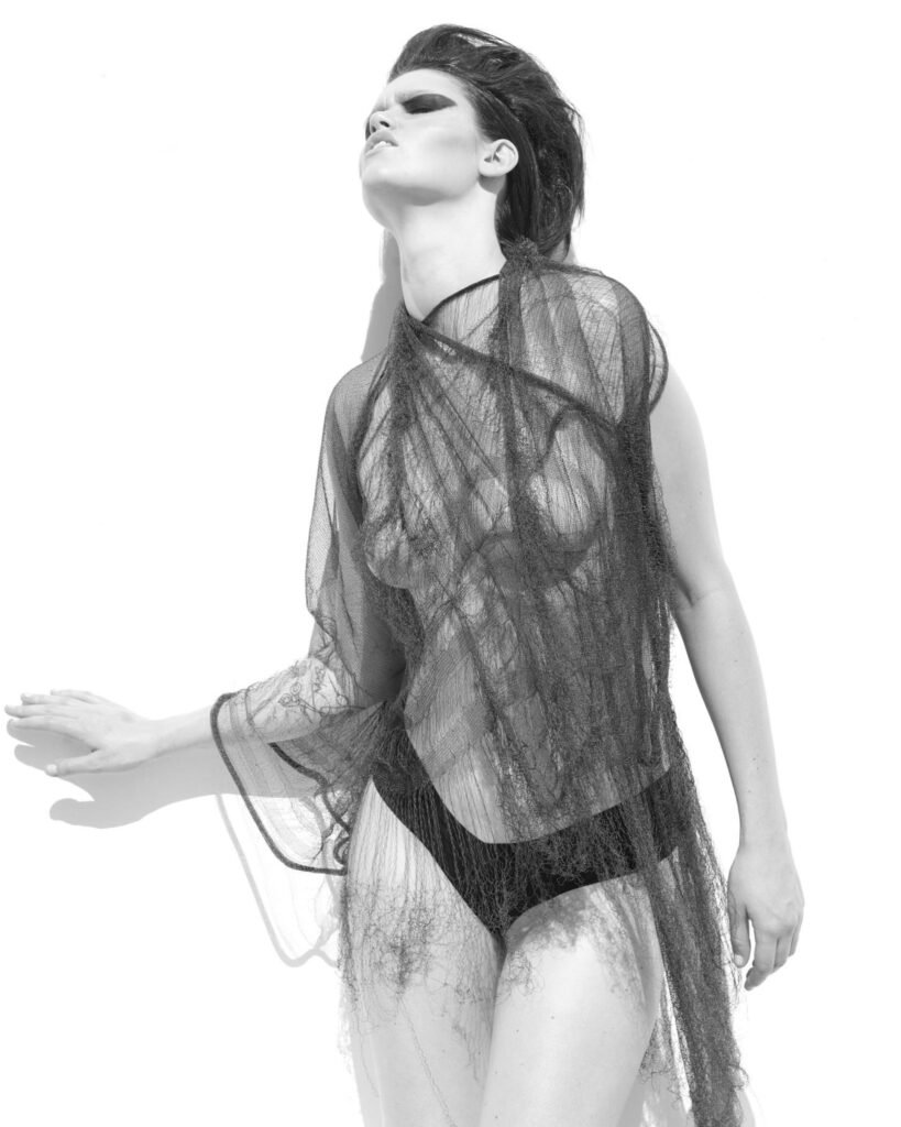 Model wearing a grey knit transparent garment